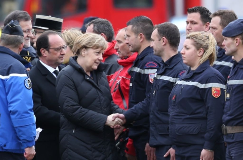 Angela Merkel kommt in der Absturzregion an und spricht mit den Helfern.