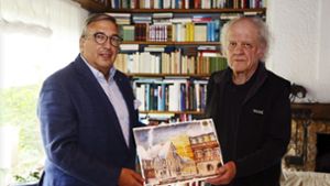 Harald von Hinüber (links) überreicht den Adventskalender mit der Glückszahl 0001 an den Künstler Franz Xaver Lutz. Foto:  