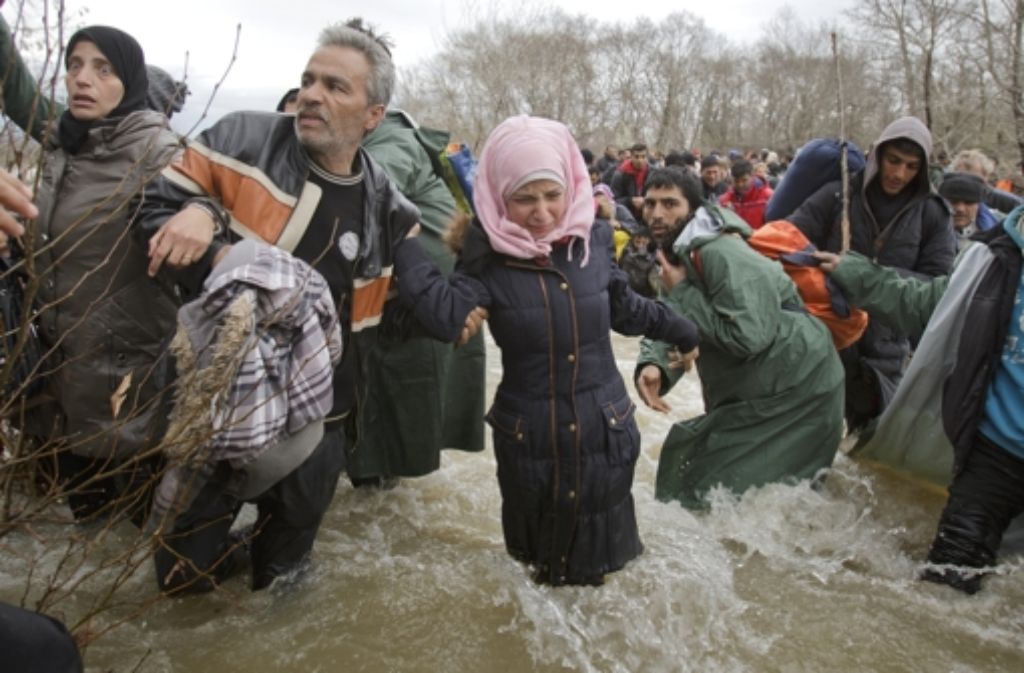Flüchtlingsfamilien versuchen am Freitag, sich nach Mazedonien durchzuschlagen. Fotografen sind dabei. Sie halten unter anderem fest, ...