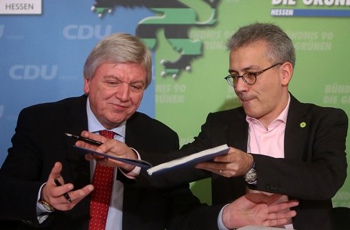 Der hessische  Ministerpräsident Volker Bouffier (CDU) und Grünen-Chef Tarek Al-Wazir unterschreiben den Koalitionsvertrag. Foto: dpa