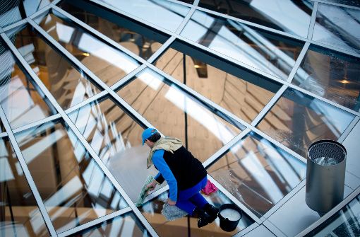 Klare Sicht auf den Bundestag: Ein Arbeiter reinigt die Glasfenster über dem Plenarsaal im Berliner Reichstagsgebäude, in dem ab Herbst die neu gewählten Abgeordneten tagen werden. Foto: dpa