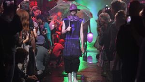 Mit Boots, Hut und Schirm ist das Model der Raf Simons Fashionshow für den Regen gerüstet. Foto: AFP