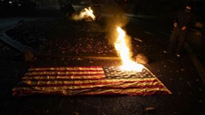 Aktivisten haben US-Flaggen angezündet. Foto: dpa/Marcio Jose Sanchez