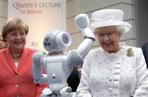 Ein kleiner Roboter grüßt die Queen: Elizabeth II. und Angela Merkel an der Technischen Universität in Berlin. Foto: dpa