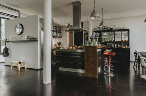 Eine Kücheninsel mit schwarzer Front und Holzelementen ist typisch für eine moderne Küche. Foto: imago/Mareen Fischinger