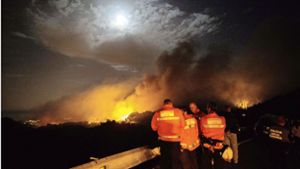 Feuerwehrleute beraten sich während des Einsatzes:  Der Waldbrand in den Bergen von Gran Canaria ist nach Behördenangaben außer Kontrolle geraten. Foto: AFP