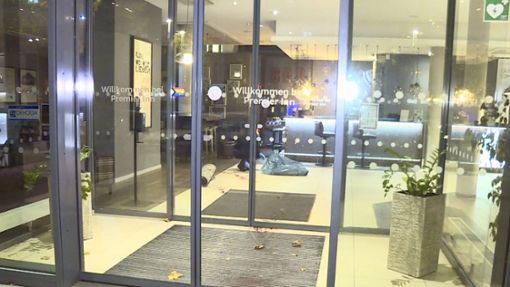Ein Mitarbeiter der Spurensicherung rollt einen blutigen Teppich  im Eingangsbereich eines Hotels in Hannover ein. Foto: dpa