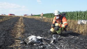 Ein Feuerwehrmann betrachtet das komplett zerstörte Modellflugzeug. Foto: Feuerwehr Ditzingen/z