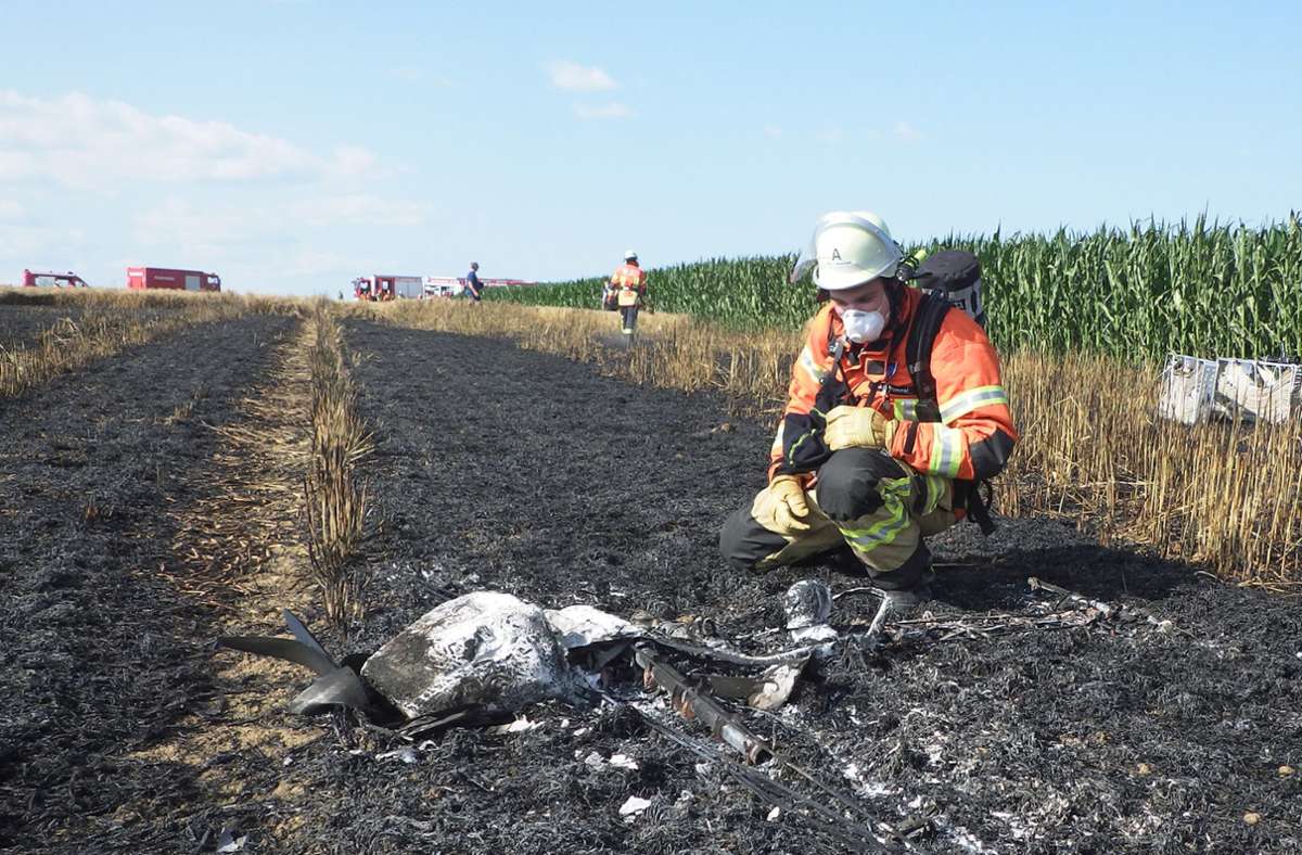 Ein Feuerwehrmann betrachtet das komplett zerstörte Modellflugzeug. Foto: Feuerwehr Ditzingen/z