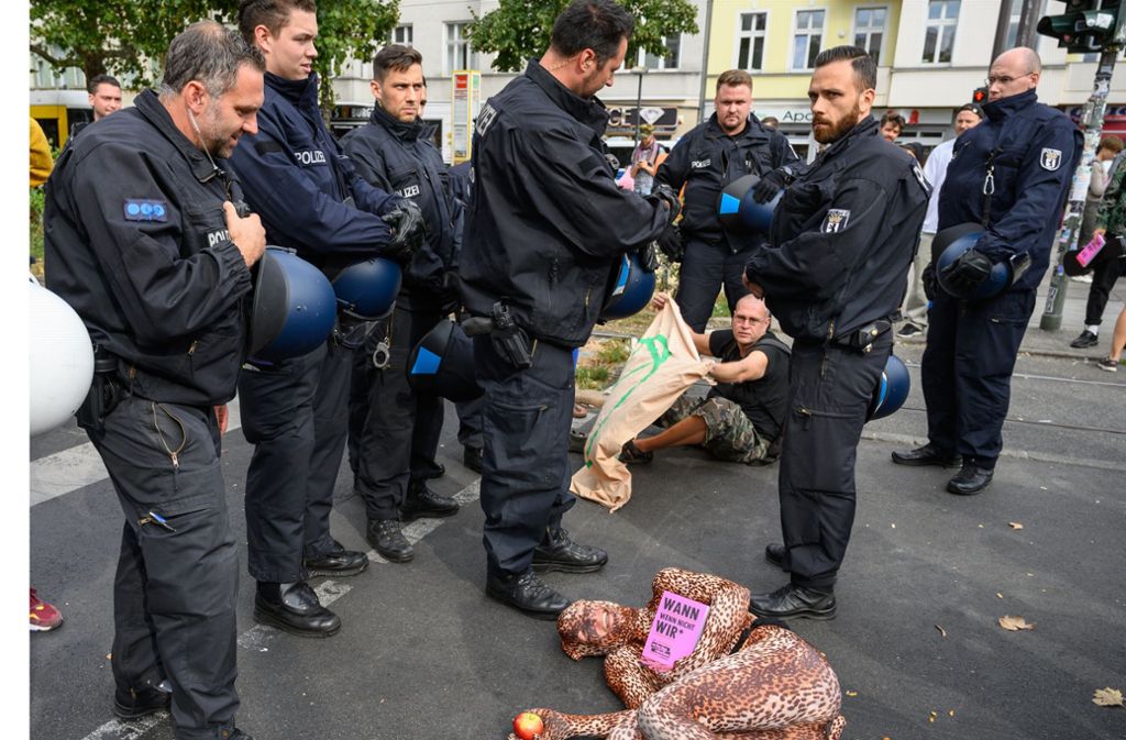 Die Initiative stammt aus England. In Deutschland gab es bisher erst wenige Aktionen – wie diese hier Anfang September in Berlin. Eine Klimaaktivistin liegt bei einer Straßenblockade vor Polizisten.