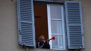 Ein Mann steht an einem geöffneten Fenster, und nimmt am «Flashmob sonoro» (klingender Flashmob) teil. Foto: dpa/Elisa Lingria