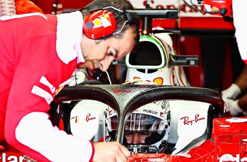 Ein Ferrari-Techniker schraubt an Halo (schwarz) herum – und Sebastian Vettel wartet geduldig. Foto: Getty