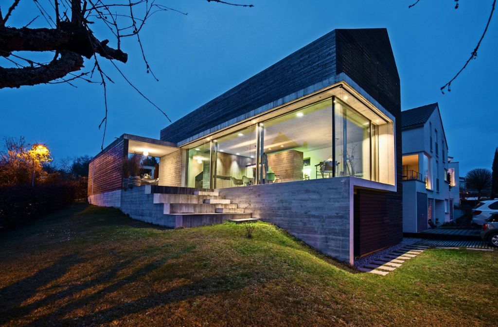 Die große, über Eck gezogene Fensterfront und das asymmetrische Satteldach geben dem Haus ein eigenes  Gesicht.