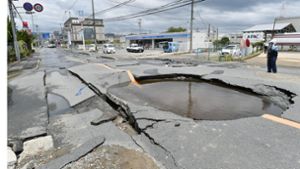 Ein mit Wasser gefüllter Krater auf einer Straße in Osaka, nachdem Wasserrohre nach einem Erdbeben gebrochen waren. Foto: Kyodo News