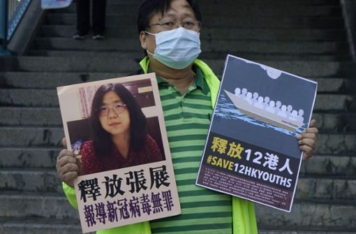 Ein pro-demokratischer Aktivist fordert die Freilassung von Zhang (linkes Plakat) sowie der 12 Hongkonger Aktivisten, die von den chinesischen Behörden auf See festgehalten werden. Foto: dpa/Kin Cheung