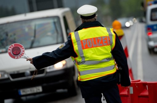 Ein Polizist kontrolliert nach Deutschland einreisende Autos. Foto: dpa