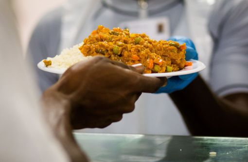 Beim Fastenbrechen in der Landeserstaufnahmeeinrichtung (LEA) in Ellwangen nimmt ein Flüchtling, der an Ramadan teilnimmt, in der Kantine ein Fischgericht mit Reis entgegen. Foto: dpa