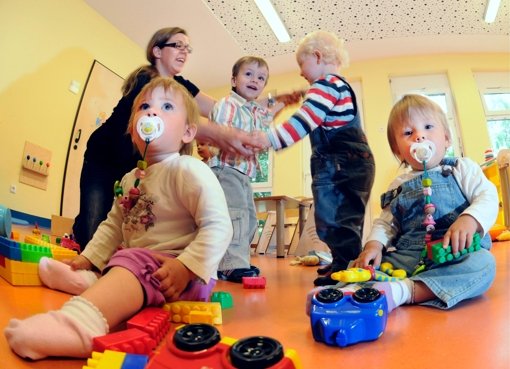 Eine Erzieherin betreut Kinder in einer Kindetagesstätte Foto: dapd