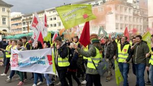 Mitarbeiter des Landes Baden-Württemberg laufen mit Fahnen und Transparenten zu einer Kundgebung. Foto: dpa