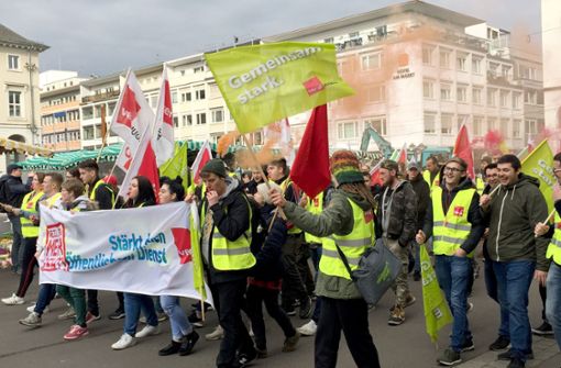 Mitarbeiter des Landes Baden-Württemberg laufen mit Fahnen und Transparenten zu einer Kundgebung. Foto: dpa
