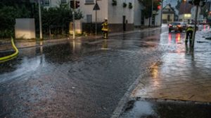 Mit Schläuchen wurde die Straße von den Wassermassen befreit.   Foto: SDMG