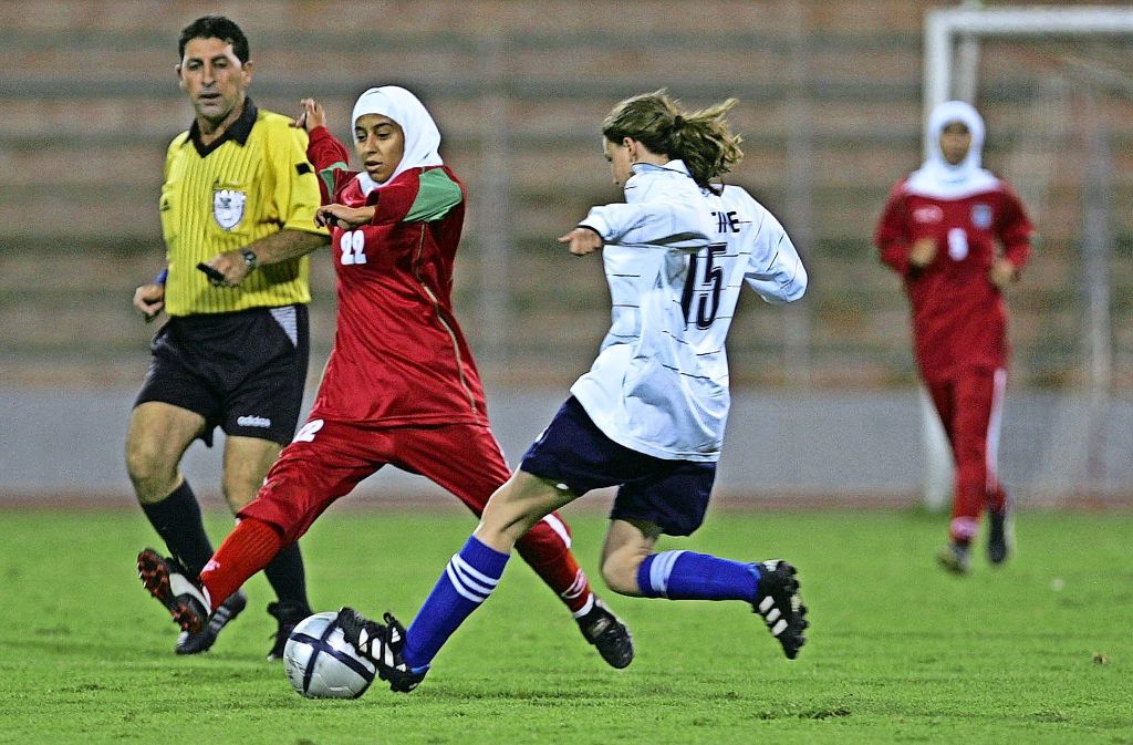 Die iranische Fußballerin  Saedeh Ahmadi (rotes Trikot) spielt wie ihre Teamkolleginnen mit Kopftuch und langen Hosen. Foto: AFP