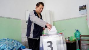 Ein Mann in einem Krankenhaus von Berdyansk wählt mit einer mobilen Wahlurne. Foto: AFP/STRINGER