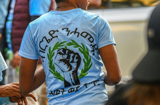 Eine Faust ist auf dem T-Shirt eines Mannes zu sehen, der zu einer Gruppe gehört, die nach Ausschreitungen bei einer Eritrea-Veranstaltung in Stuttgart von Polizeikräften eingekesselt sind. Foto: dpa/Jason Tschepljakow