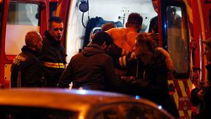 Hilfskräfte versorgen einen verwundeten Mann in der Nähe des Stade de France. Foto: dpa