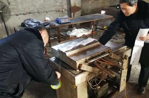 Nahrungsmittelinspektoren versiegeln eine Maschine, mit der gefälschtes Eselburgerfleisch hergestellt worden ist. Foto: AFP
