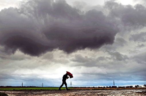 Ein Spaziergänger kämpft sich durch das schlechte Wetter Foto: dpa