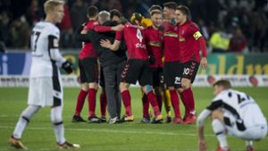 Die Freiburger Spieler jubeln über den Sieg. Foto: dpa