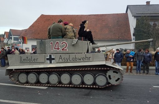 Ein Panzer mit der Aufschrift „Ilmtaler Asylabwehr“ nimmt am Sonntag an einem Faschingsumzug in Reichertshausen im Landkreis Pfaffenhofen (Bayern) teil. Die Behörden ermitteln nun wegen des Verdachts der Volksverhetzung. Foto: dpa