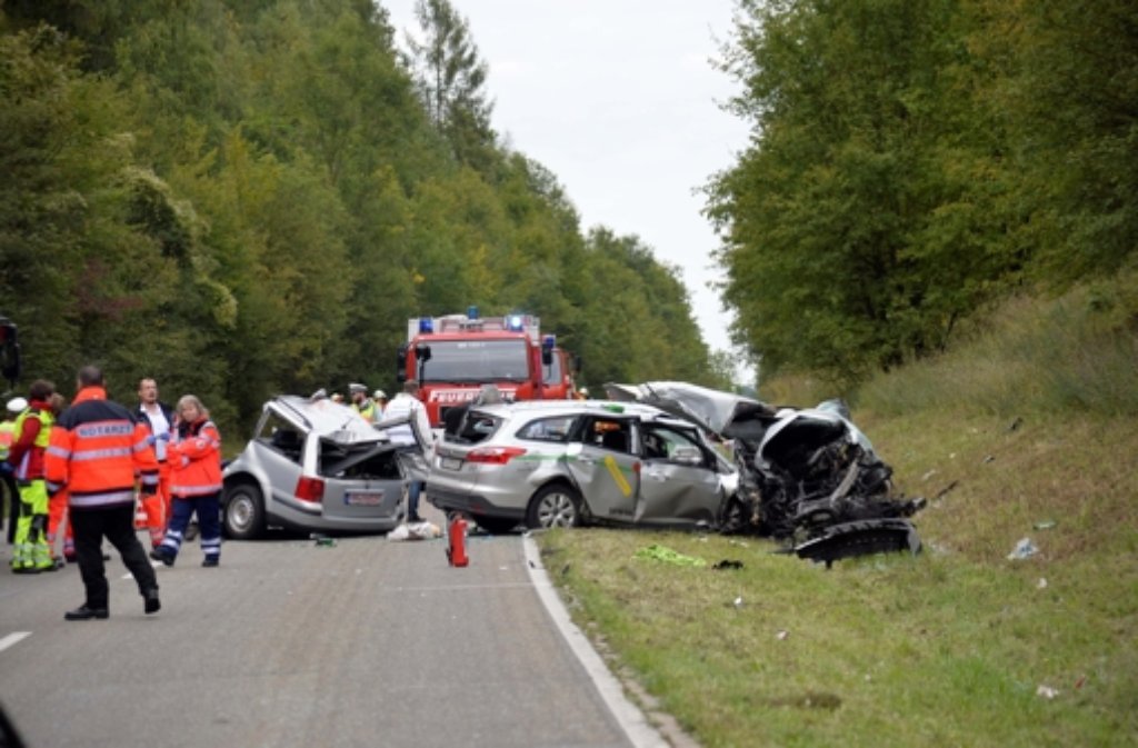Rettungskräfte stehen nach dem tödlichen Unfall in der Nähe von Bad Rappenau (Baden-Württemberg) neben völlig zerstörten Fahrzeugen. Bei dem Unfall starben vier Menschen. Foto: dpa