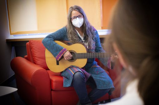 Singen ist wegen Corona nicht erlaubt, und so summt Sabine Rachl unter ihrer Maske zum Spiel  der Gitarre. Foto: Ines Rudel