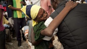 Leid auf Haiti: Ein Vater stützt seinen an Cholera erkrankten Sohn in einem haitianischen Krankenhaus. Foto: dpa