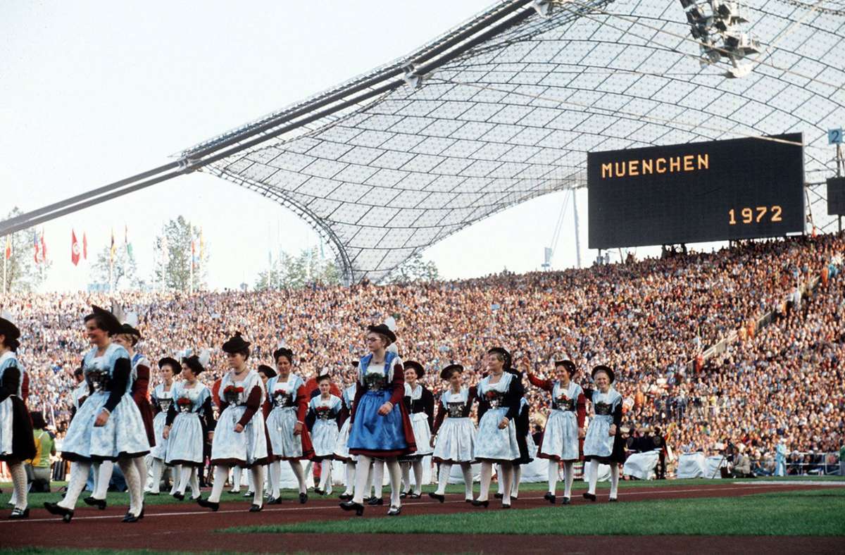 Bei der Eröffnungsfeier marschieren fesche Hostessen in bayrischer Landestracht ins Münchner Olympiastadion.