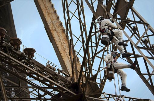 Der Eiffelturm bekommt einen neuen Anstrich. Doch nun wurden die Arbeiten unterbrochen, da durch das Entfernen der alten Farbschichten Blei freigesetzt wird. Foto: AFP/Martin Bureau