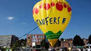 Mit Seilen gesichert und von Schaulustigen beobachtet, wird der neue Staufers-Heißluftballon für die     Segnungszeremonie vorbereitet. Foto: Ines Rudel