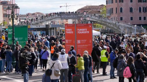 Vor dem Hauptbahnhof überprüfen Kontrolleure den QR-Code der Touristen, mit dem die Zahlung nachgewiesen wird. Foto: Luca Bruno/AP/dpa