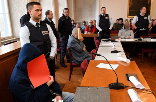 Zwei der drei Angeklagten haben zum Prozessauftakt am Landgericht Ellwangen ihre Gesichter verdeckt. Foto: dpa/Stefan Puchner