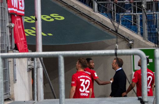 Bayern-Spieler und Trainer Hansi Flick reden auf die Fans ein. Foto: dpa/Tom Weller