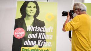 Die Grünen-Kanzlerkandidatin Annalena Baerbock, derzeit in Urlaub,  auf einem Wahlplakat Foto: AFP/Stefanie Loos
