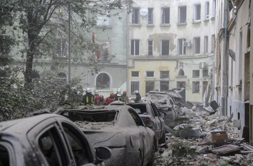 Rettungskräfte versammeln sich vor beschädigten Gebäuden in Lwiw, während die Suche nach Opfern nach einem Raketenangriff weitergeht. Foto: dpa/Mykola Tys