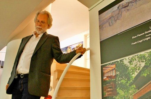 Ausstellungsmacher Professor Dr. Michael Koch (neben einer Frank-Lloyd-Wright-Tafel) kommt die geschwungene Treppe in die Ausstellungsräume des denkmalgeschützten Lee-Hauses herunter. Foto: Martin Bernklau