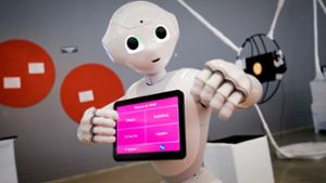 Künstliche Intelligenz gilt als wichtiges Zukunftsfeld in vielen Bereichen. Das Foto zeigt einen Roboter, der auf einer Ausstellung mit Gästen kommuniziert. Foto: dpa/Christian Charisius