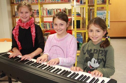 Julia, Mina und Alissa (v.l.) freuen sich über das vom Förderverein gespendete E-Piano. Foto: Bernd Zeyer