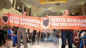 Klimaaktivistinnen der Letzten Generation haben mit Transparenten eine Show der Designerin Anja Gockel auf der Berliner Modewoche gestört. Foto: dpa/Gerald Matzka