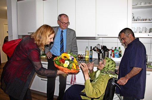 Bürgermeisterin Isabel Fezer und Helmuth Caesar, der Technische Geschäftsführer der SWSG,    überreichten  einer türkischstämmigen Bewohnerin der Wohngemeinschaft „Emin Eller“ einen Blumenstrauß und  eine Tasche mit Geschenken. Foto: Georg Friedel