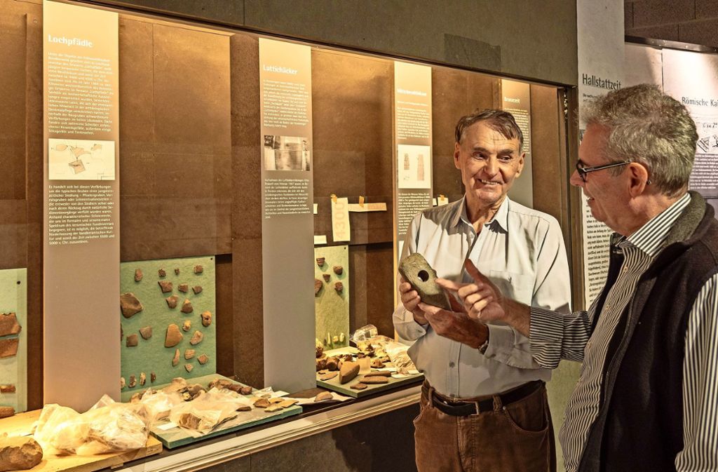Besuch während des Ausstellungsaufbaus: Der Kurator Tiberius Bader erklärt ein Beil, das sich ein Steinzeitmensch als Werkzeug mühsam geschaffen hat. Foto: factum/Weise